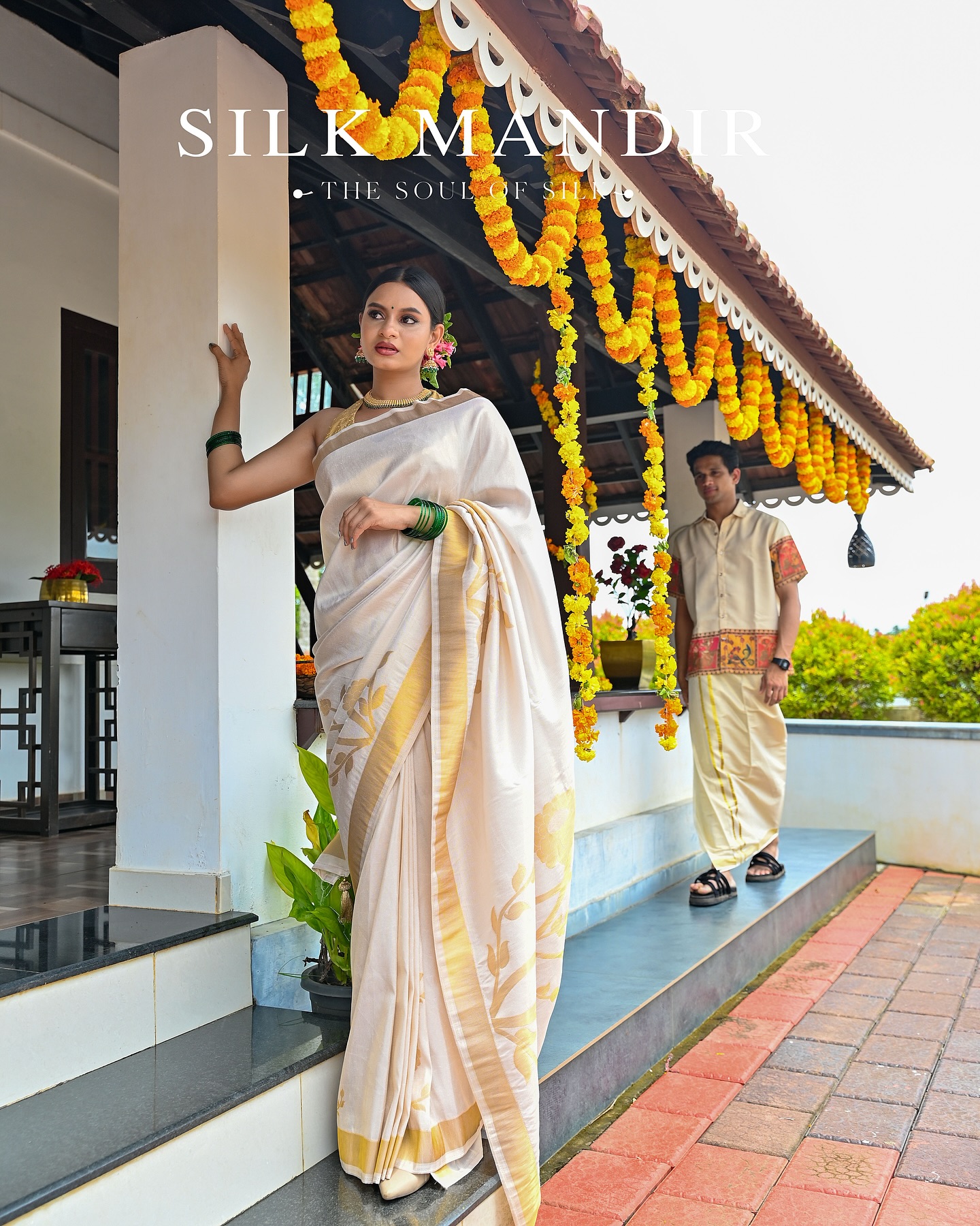 A woman in cream kasavu under marigold garlands